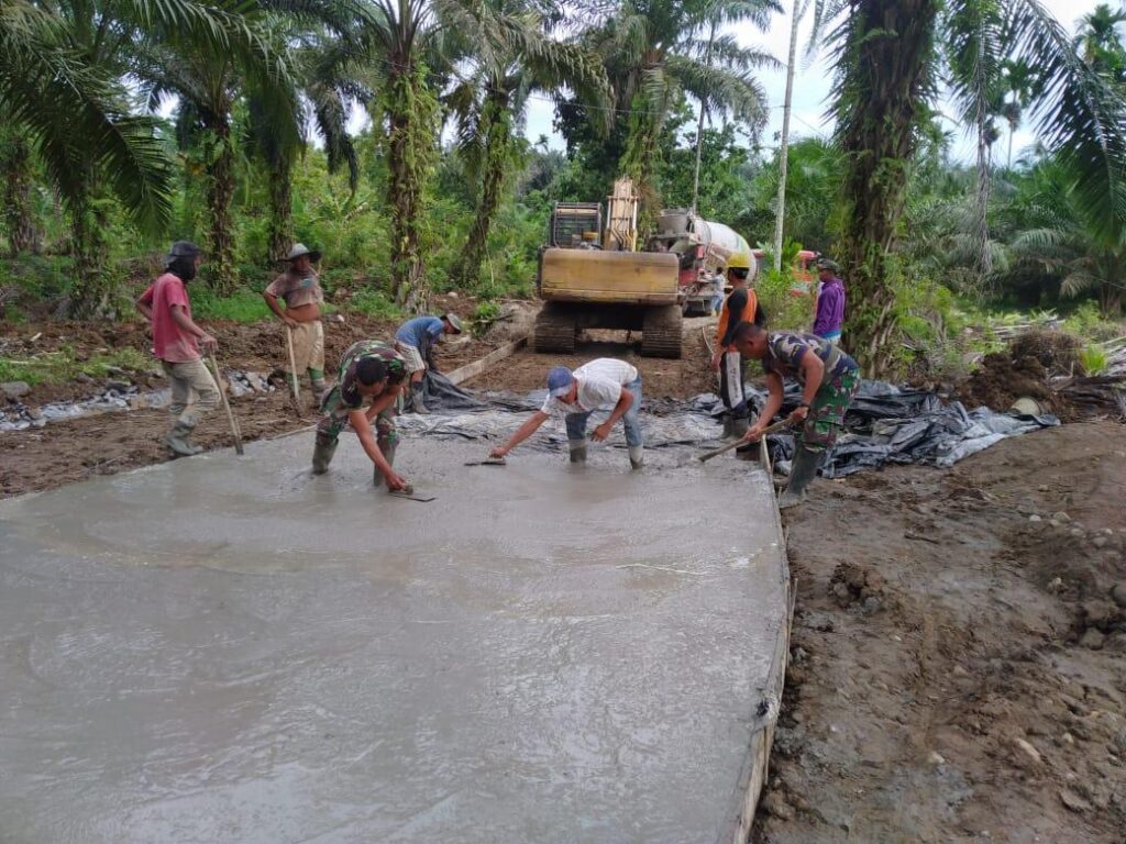 Tak Mau Ketinggalan, Wakapolsek Bangun Purba Ikut Ngecor Jalan TMMD Kodim 0204/DS